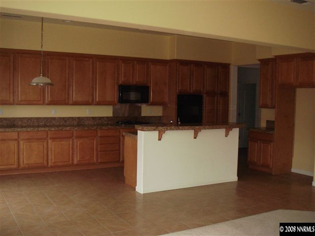 1045 South University Park Loop Reno, NV 89512 - Photo 3 of 9 a kitchen with stainless steel appliances wooden cabinets and a refrigerator