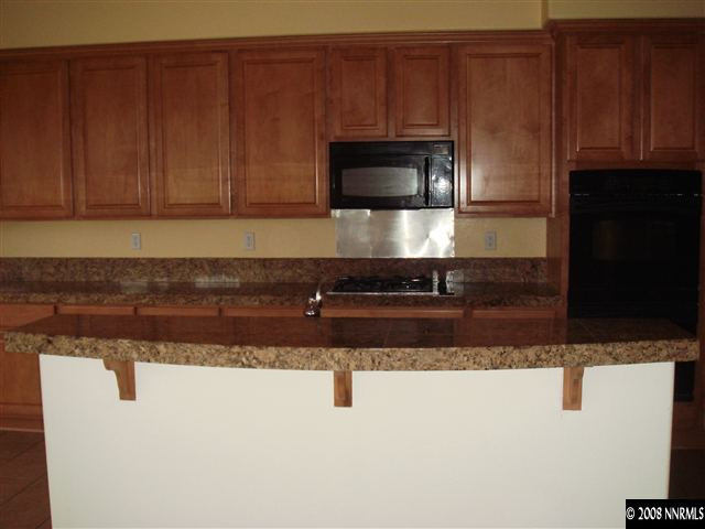 1045 South University Park Loop Reno, NV 89512 - Photo 4 of 9 a kitchen with granite countertop cabinets and steel appliances