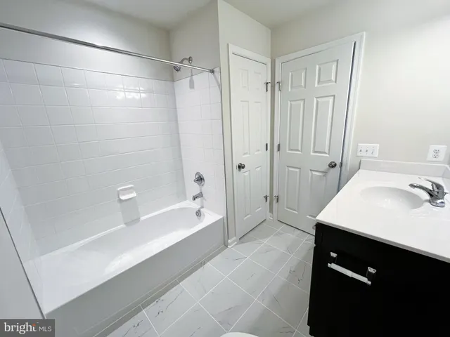a en suite bathroom with a granite countertop sink a toilet and shower