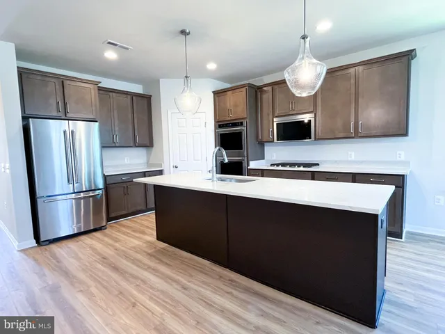 a kitchen with a sink stainless steel appliances a refrigerator and a counter top