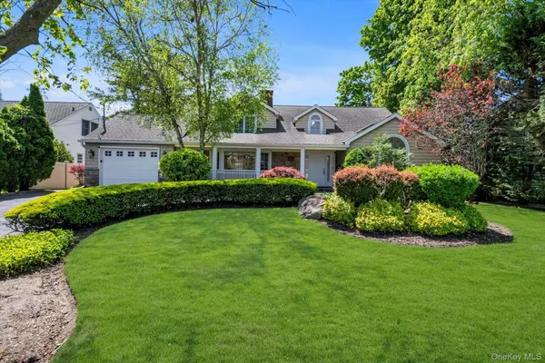 a front view of a house with a garden and plants
