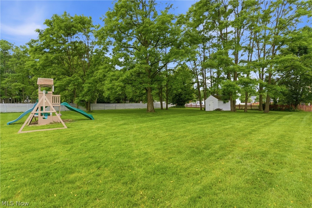 11678 Dunham Road Northfield, OH 44067 - Photo 34 of 38 Expansive green lawn with mature trees and a white privacy fence