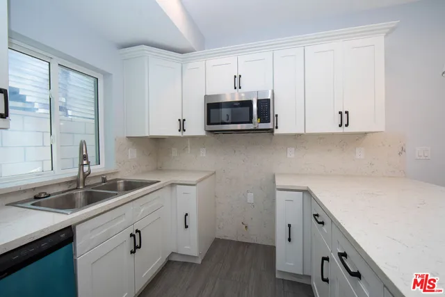 a kitchen with stainless steel appliances granite countertop a sink a stove and a microwave