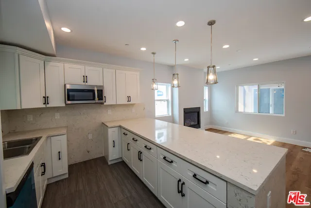 a kitchen with granite countertop white cabinets and white appliances
