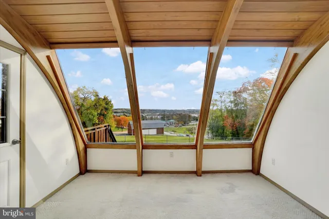 a view of a room with wooden floor kitchen and windows
