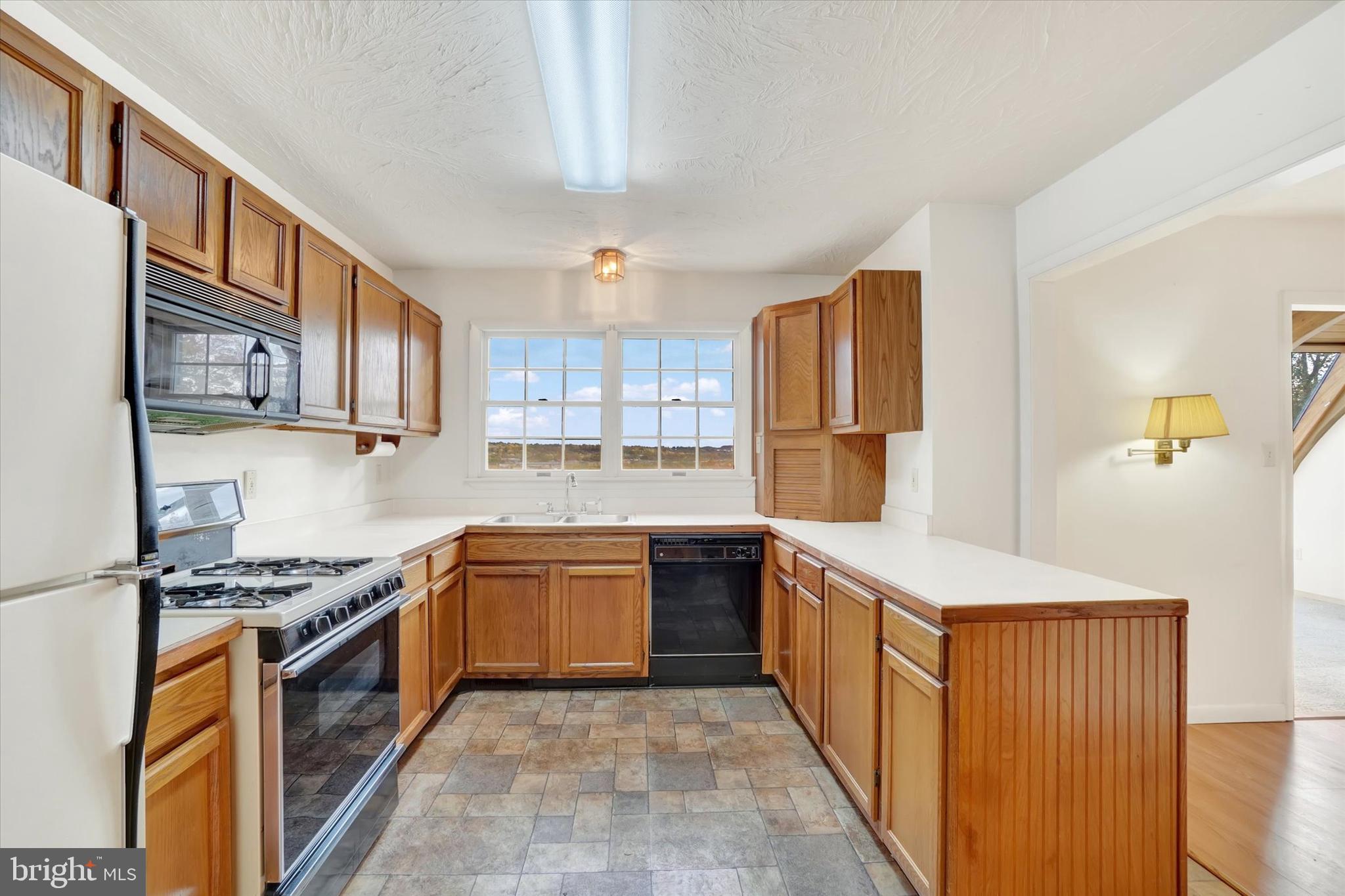 34 Jean Lo Way York, PA 17406 - Photo 8 of 27 a kitchen with stainless steel appliances granite countertop a stove top oven a sink dishwasher and a refrigerator with wooden cabinets