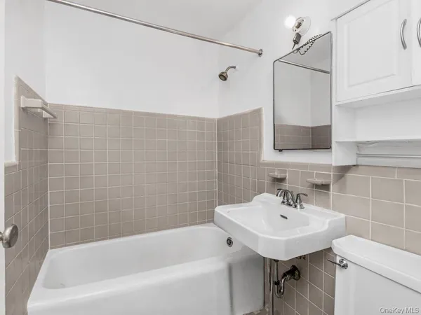 a bathroom with a sink a mirror toilet and bathtub