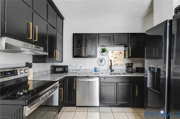 a kitchen with granite countertop stainless steel appliances a stove and a microwave