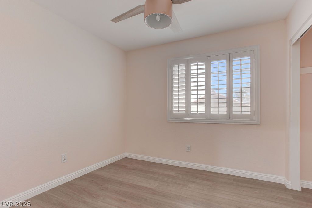 1416 Walstone Road North Las Vegas, NV 89031 - Photo 29 of 47 Laminate flooring and a bright window with shutters define this inviting bedroom space.