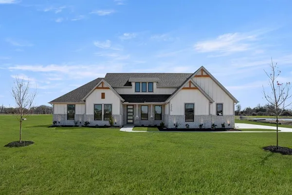 a front view of house with a garden and yard