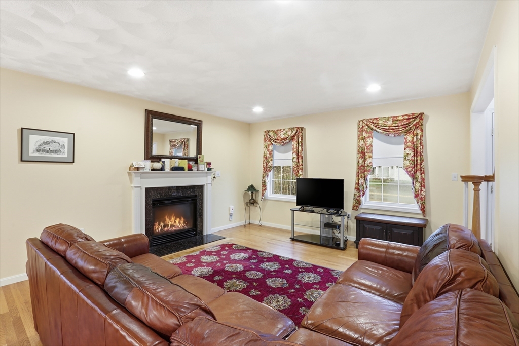 233 Bartholomew Street Peabody, MA 01960 - Photo 11 of 37 a living room with furniture a flat screen tv and a fireplace