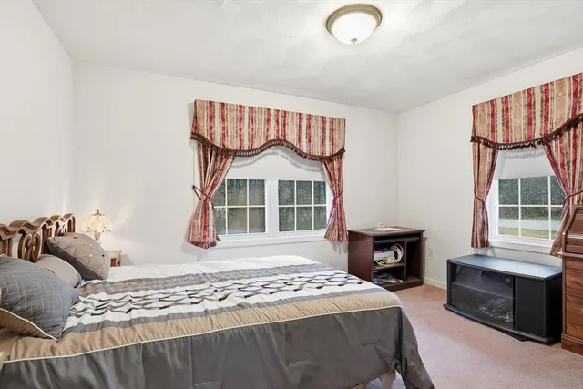 a bedroom with a bed a window and a television