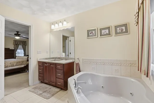 a bathroom with a tub sink and mirror