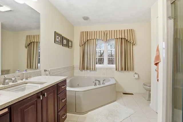 a bathroom with a tub sink and mirror