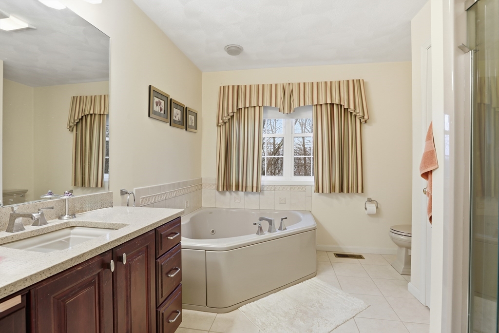 233 Bartholomew Street Peabody, MA 01960 - Photo 28 of 37 a bathroom with a tub sink and mirror