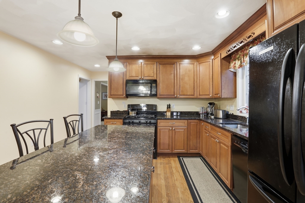 233 Bartholomew Street Peabody, MA 01960 - Photo 6 of 37 a kitchen with stainless steel appliances granite countertop a refrigerator a stove top oven a sink and dishwasher