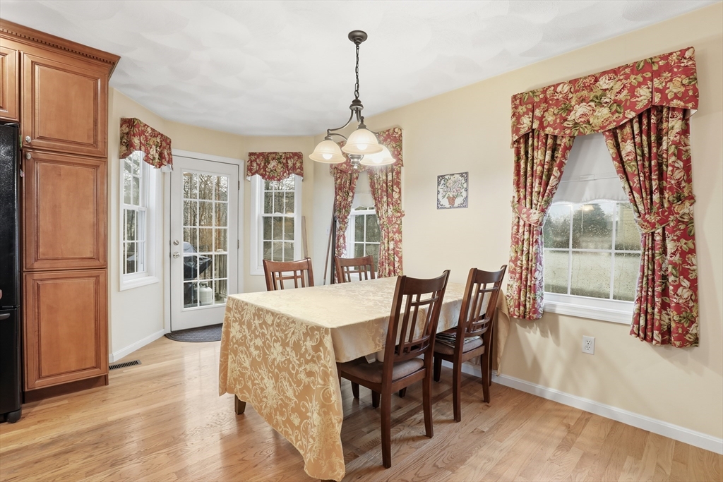 233 Bartholomew Street Peabody, MA 01960 - Photo 9 of 37 a dining room with wooden floor a chandelier a wooden table and chairs