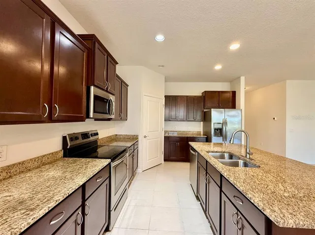 a kitchen with granite countertop stainless steel appliances and wooden cabinets
