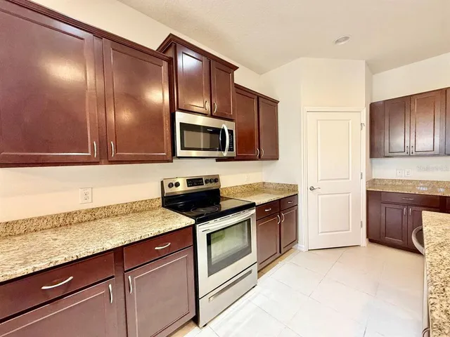 a kitchen with stainless steel appliances granite countertop a refrigerator and a sink