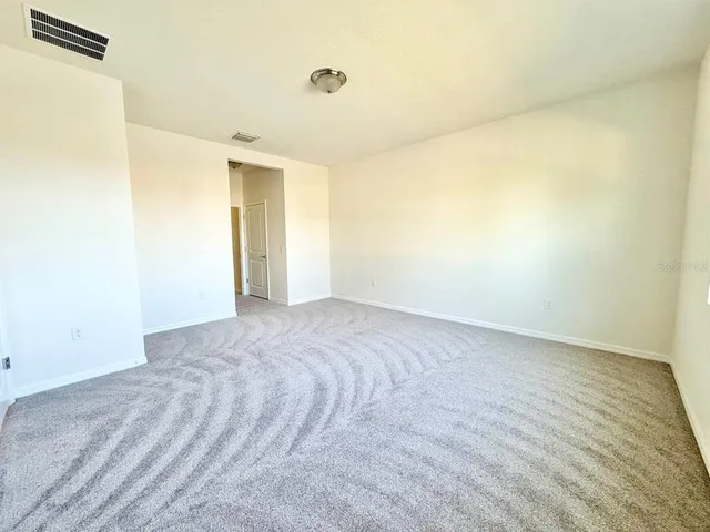 a view of a room with wooden floor and a bathroom