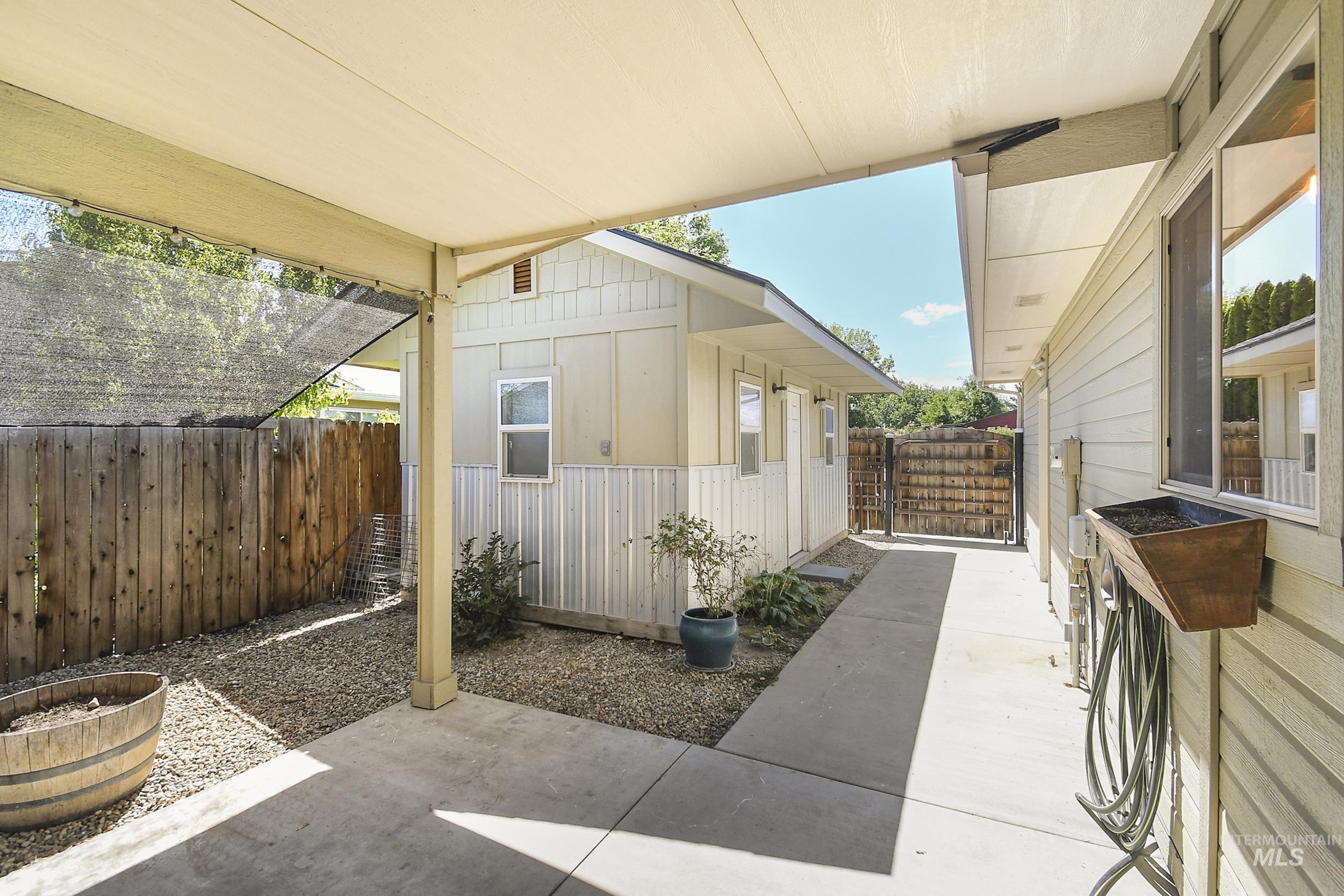 1108 East Ustick Road Caldwell, ID 83607 - Photo 25 of 30 Covered patio area featuring a concrete slab, gravel landscaping, and a wood privacy fence