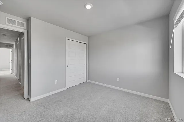 an empty room with windows and closet