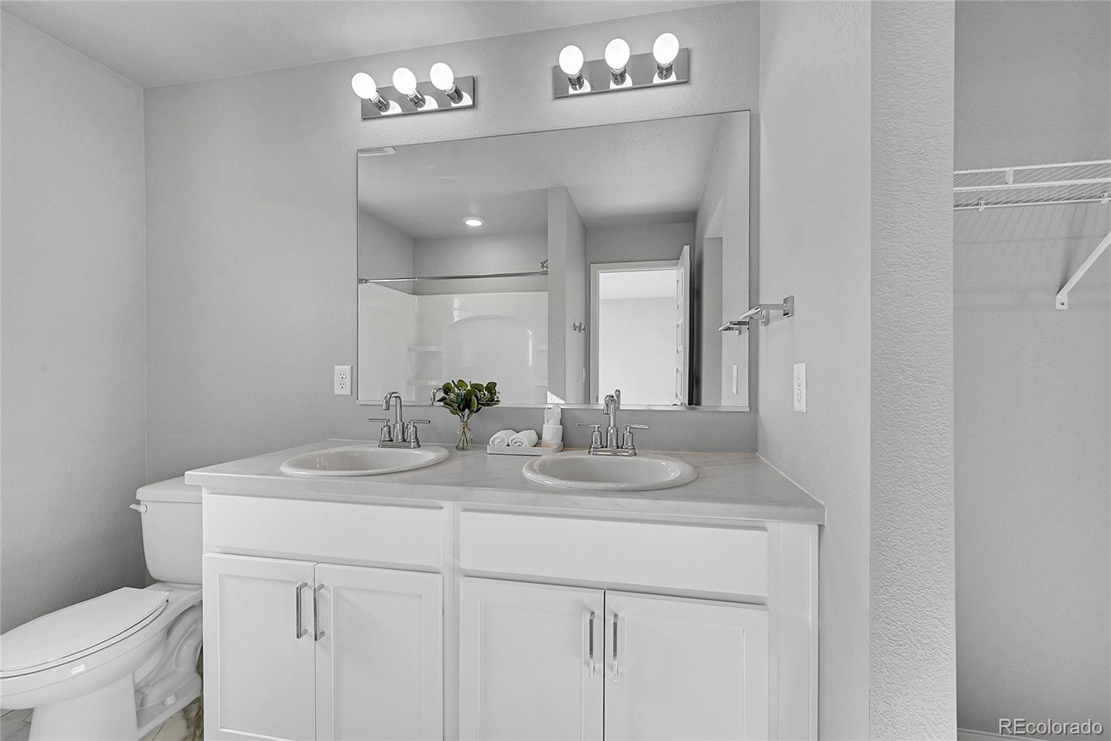 1353 Reynolds Street, Unit 3C Fort Lupton, CO 80621 - Photo 26 of 31 a bathroom with a sink a toilet and a mirror