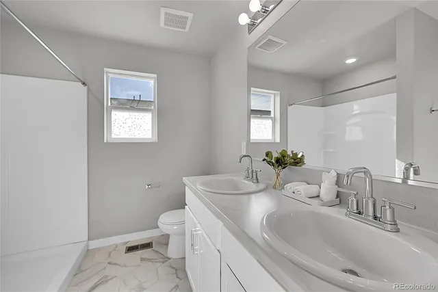 a spacious bathroom with a double vanity sink and a mirror