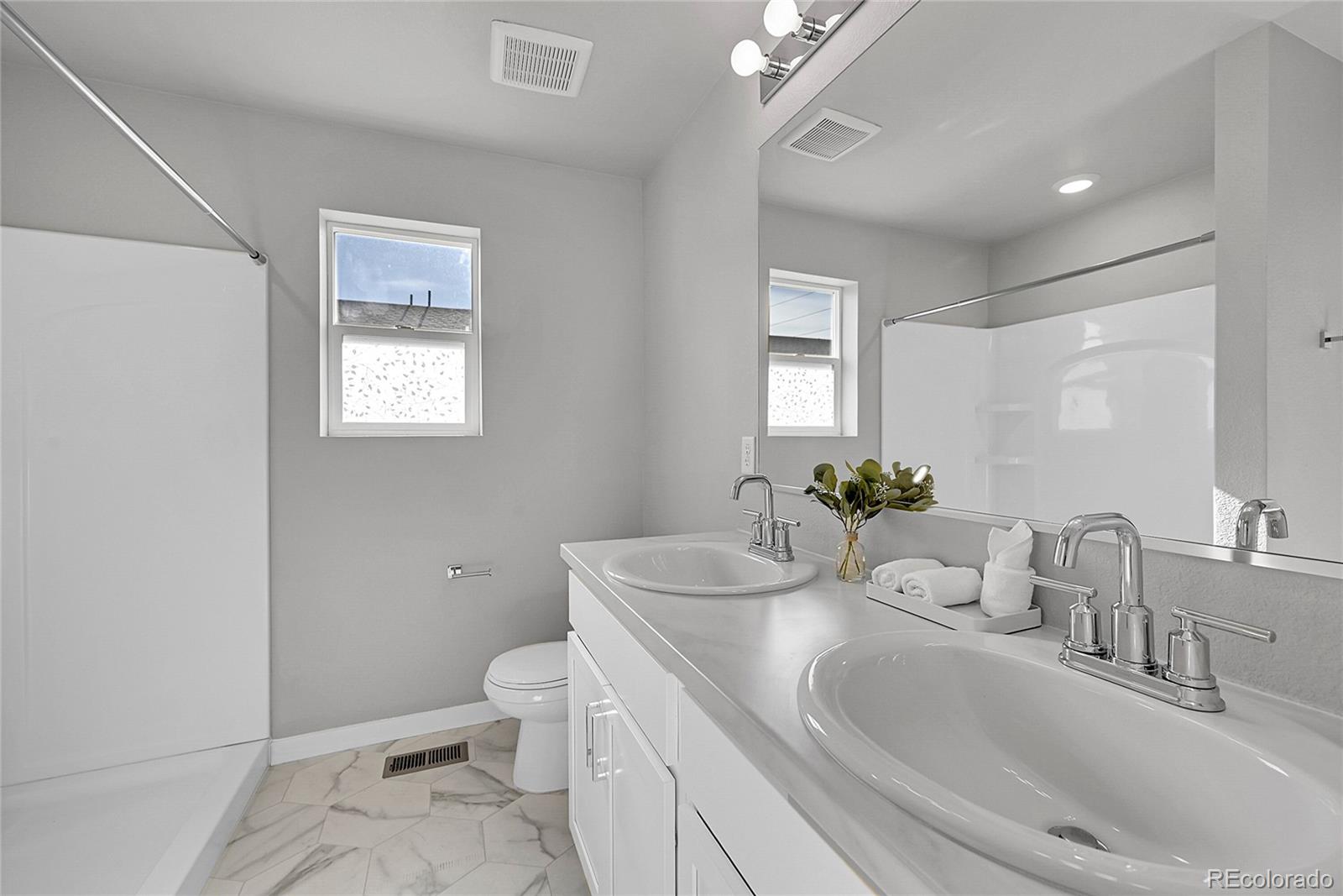 1353 Reynolds Street, Unit 3C Fort Lupton, CO 80621 - Photo 27 of 31 a bathroom with a sink a toilet and mirror