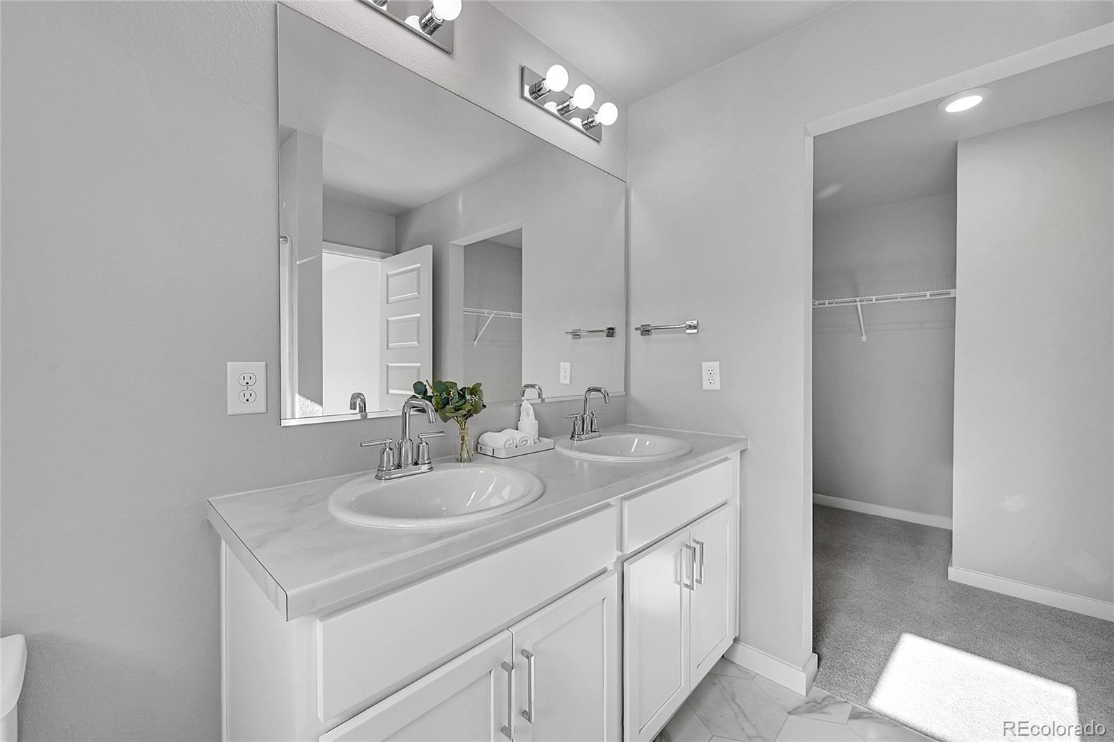 1353 Reynolds Street, Unit 3C Fort Lupton, CO 80621 - Photo 28 of 31 a spacious bathroom with a double vanity sink and a mirror