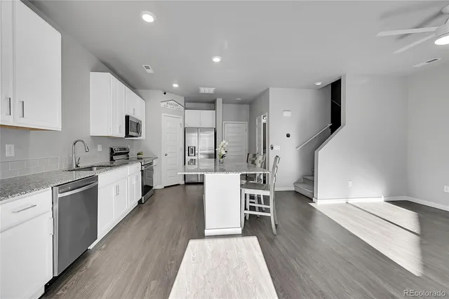 a kitchen with a sink cabinets and wooden floor