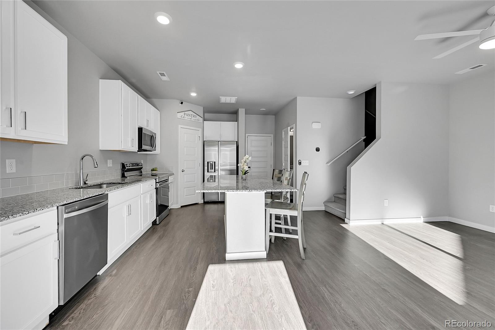 1353 Reynolds Street, Unit 3C Fort Lupton, CO 80621 - Photo 5 of 31 a kitchen with a sink cabinets and wooden floor