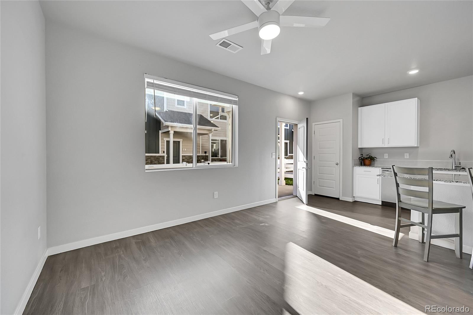 1353 Reynolds Street, Unit 3C Fort Lupton, CO 80621 - Photo 6 of 31 a view of a kitchen with wooden floor and a window