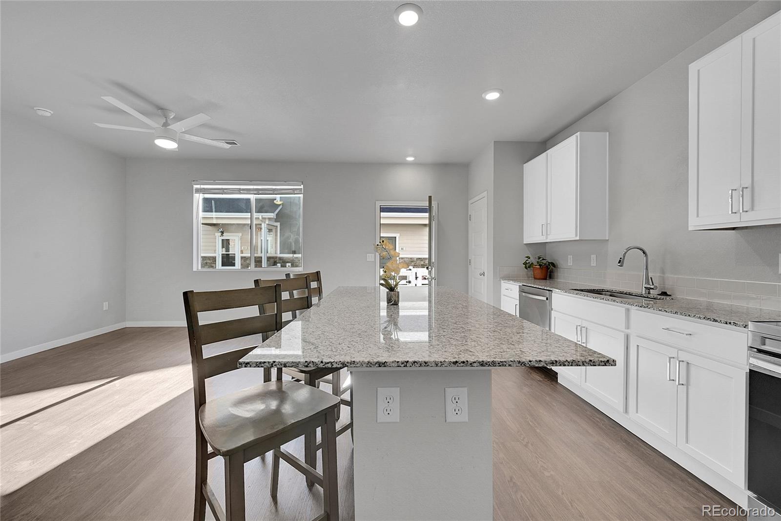1353 Reynolds Street, Unit 3C Fort Lupton, CO 80621 - Photo 7 of 31 a kitchen with sink cabinets and dining table