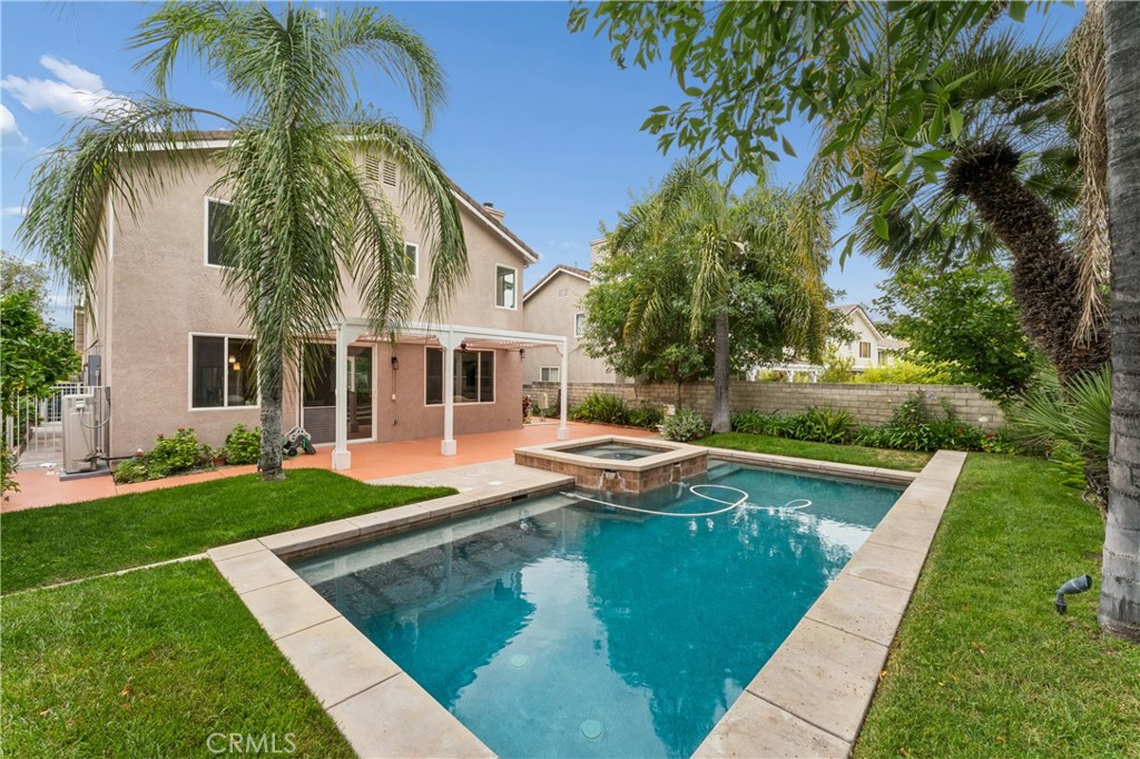 26023 Salinger Lane Stevenson Ranch, CA 91381 - Photo 28 of 35 Stunning backyard retreat complete with a sparkling pool, relaxing spa, lush palm trees, and fruit trees.