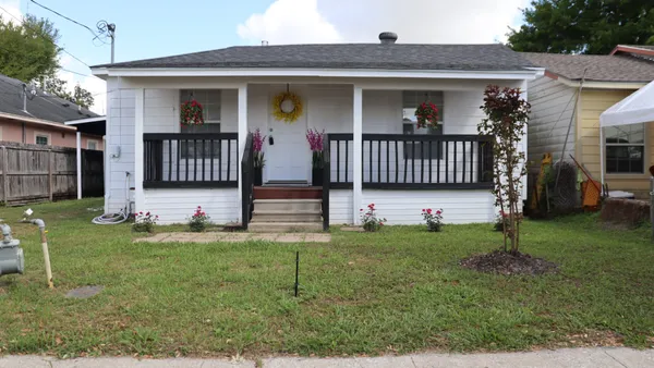 a front view of a house with yard and porch