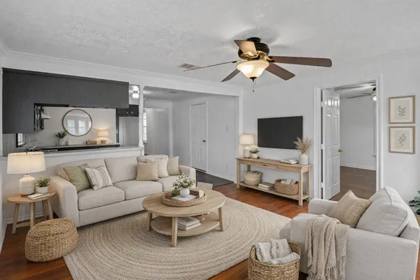 an empty room with wooden floor and a ceiling fan
