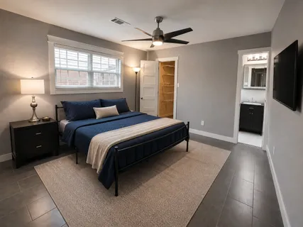 a spacious bedroom with a bed and a flat screen television