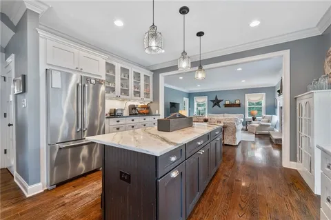 a kitchen with stainless steel appliances granite countertop a refrigerator a sink dishwasher a stove and a refrigerator with wooden floor