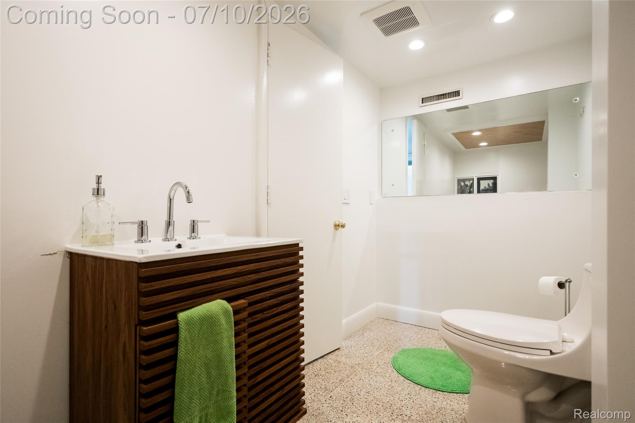 600 Middlesex Road Grosse Pointe, MI 48230 - Photo 29 of 43 Modern bathroom featuring a wood-finish slatted vanity with a white integrated sink and chrome faucet