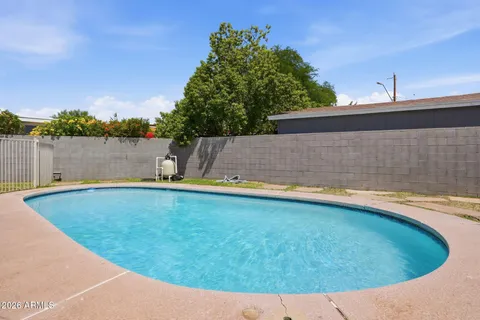 a view of a swimming pool with a yard and plants