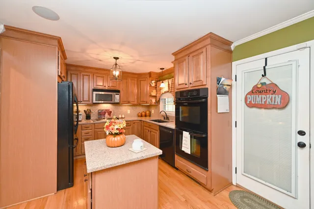 a kitchen with stainless steel appliances granite countertop a refrigerator and a stove