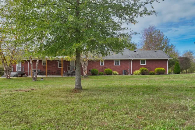 a view of a house with a yard and a tree