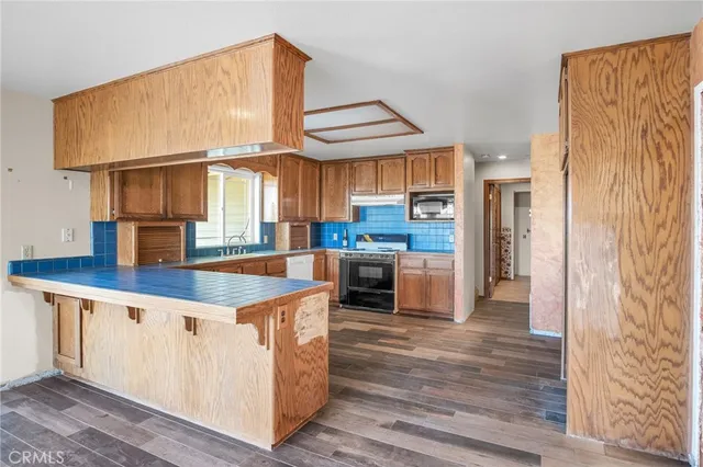 a kitchen with stainless steel appliances granite countertop a stove sink and cabinets