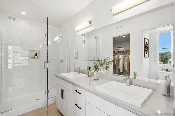 a bathroom with a double vanity sink mirror and shower