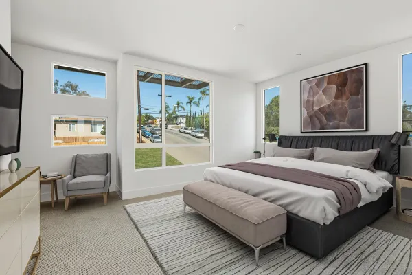 a spacious bedroom with a bed couch and a window