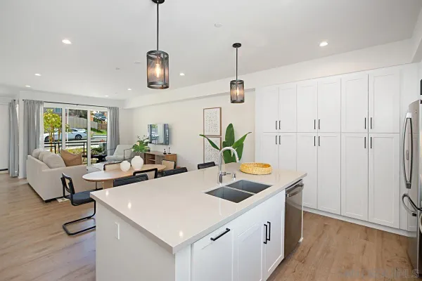 a kitchen with stainless steel appliances granite countertop a sink a stove and a wooden floors