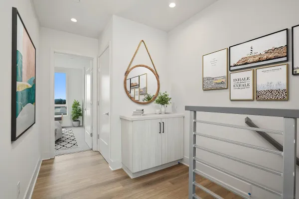 a hallway with view of wooden floor and a mirror