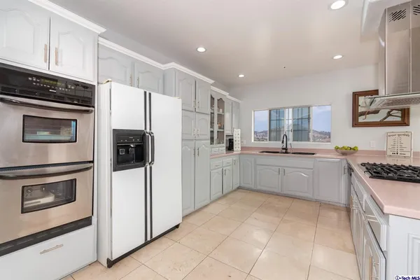 a kitchen with stainless steel appliances a refrigerator sink and stove