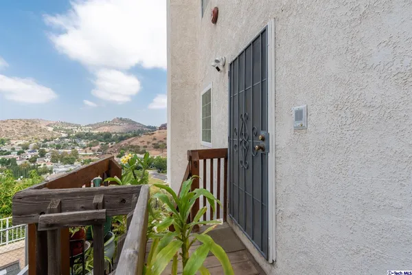 a view of a balcony with wooden floor and furniture